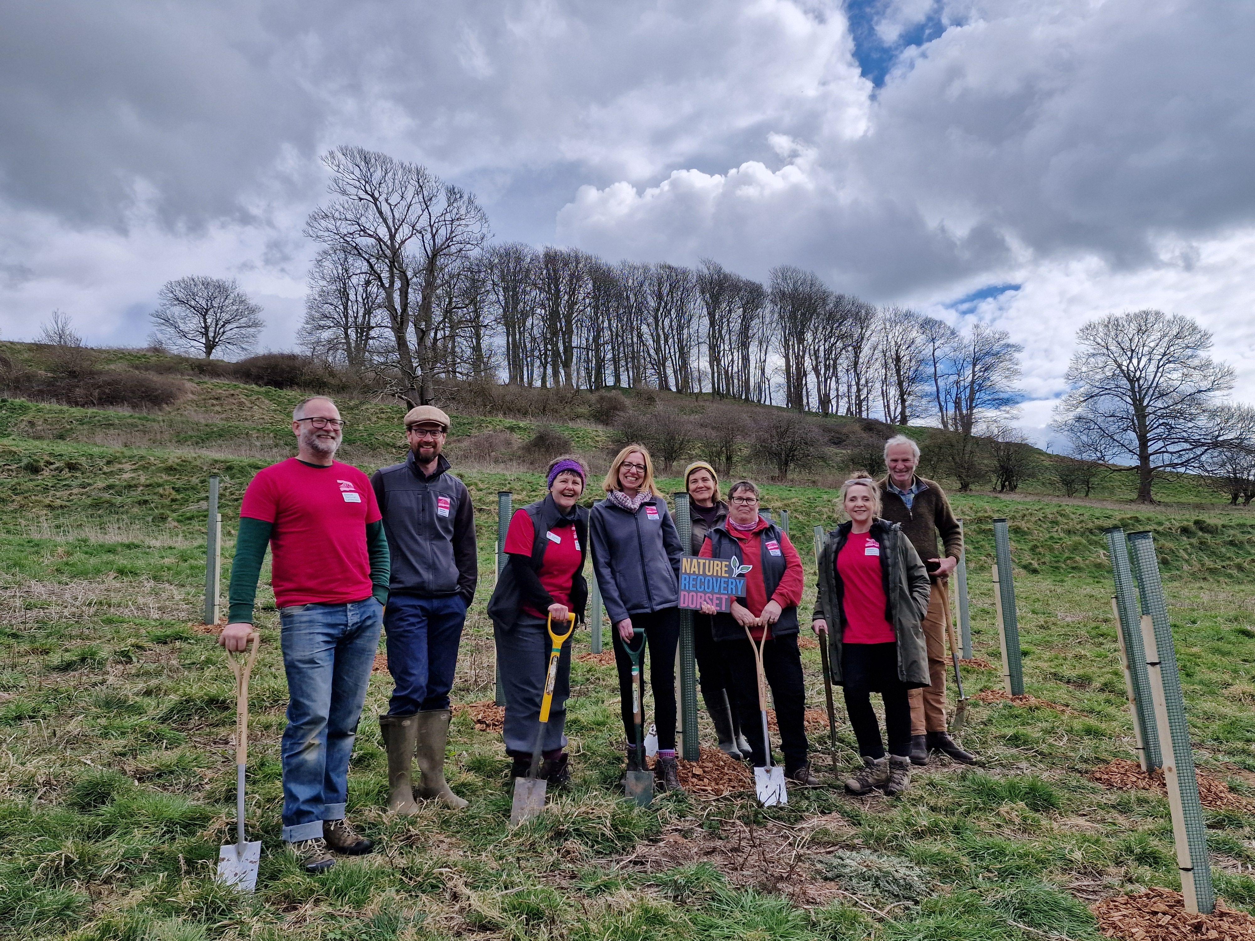 A group of men and women holding spades