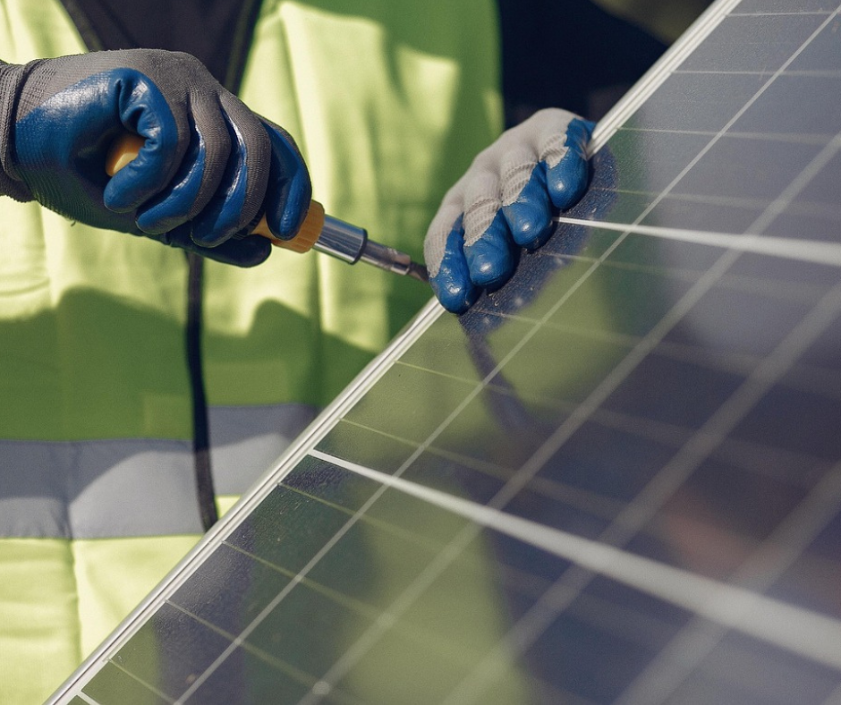 This is an image of someone fixing solar panels to a roof