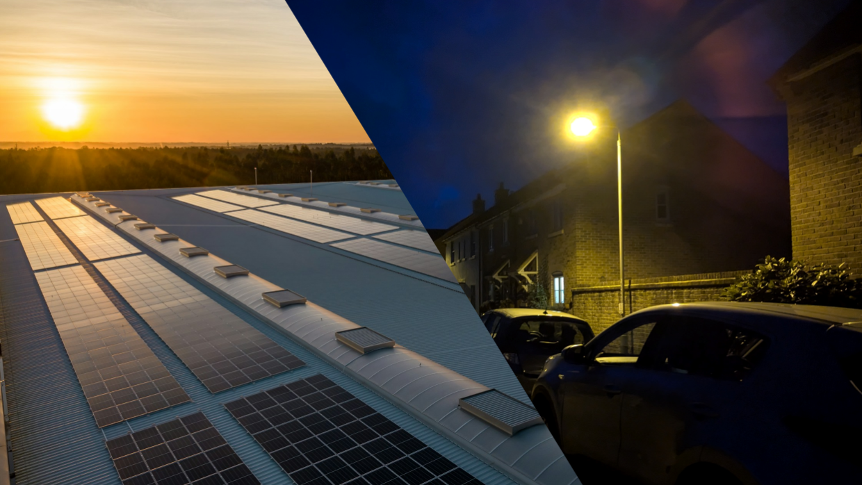 Solar panels on a building roof and street lighting on a dark residential street