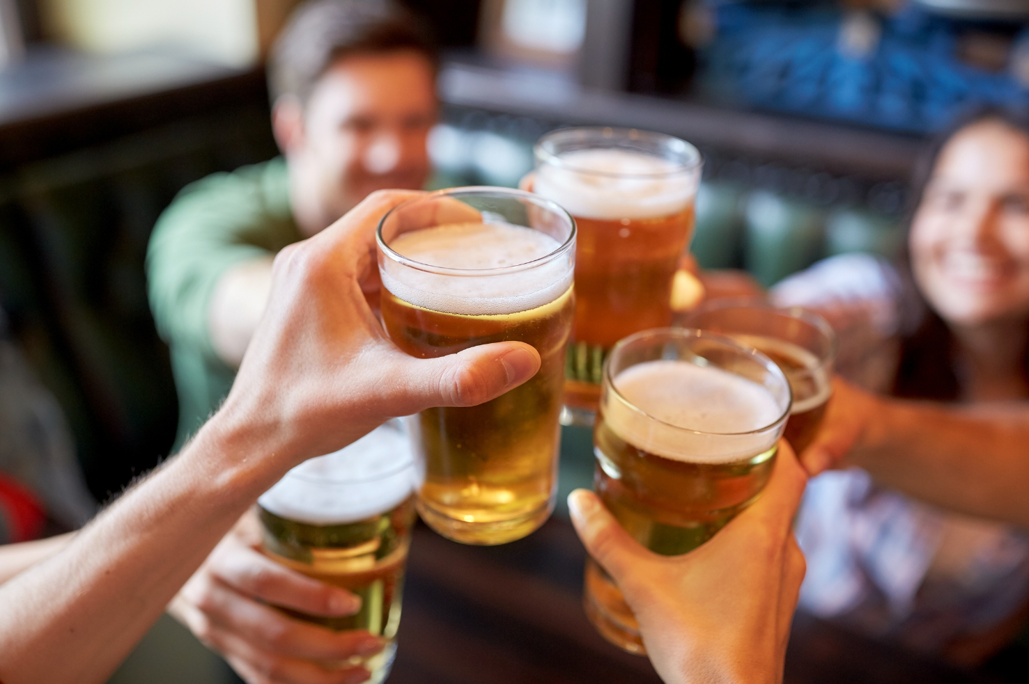 A group of people raise their pint glasses.